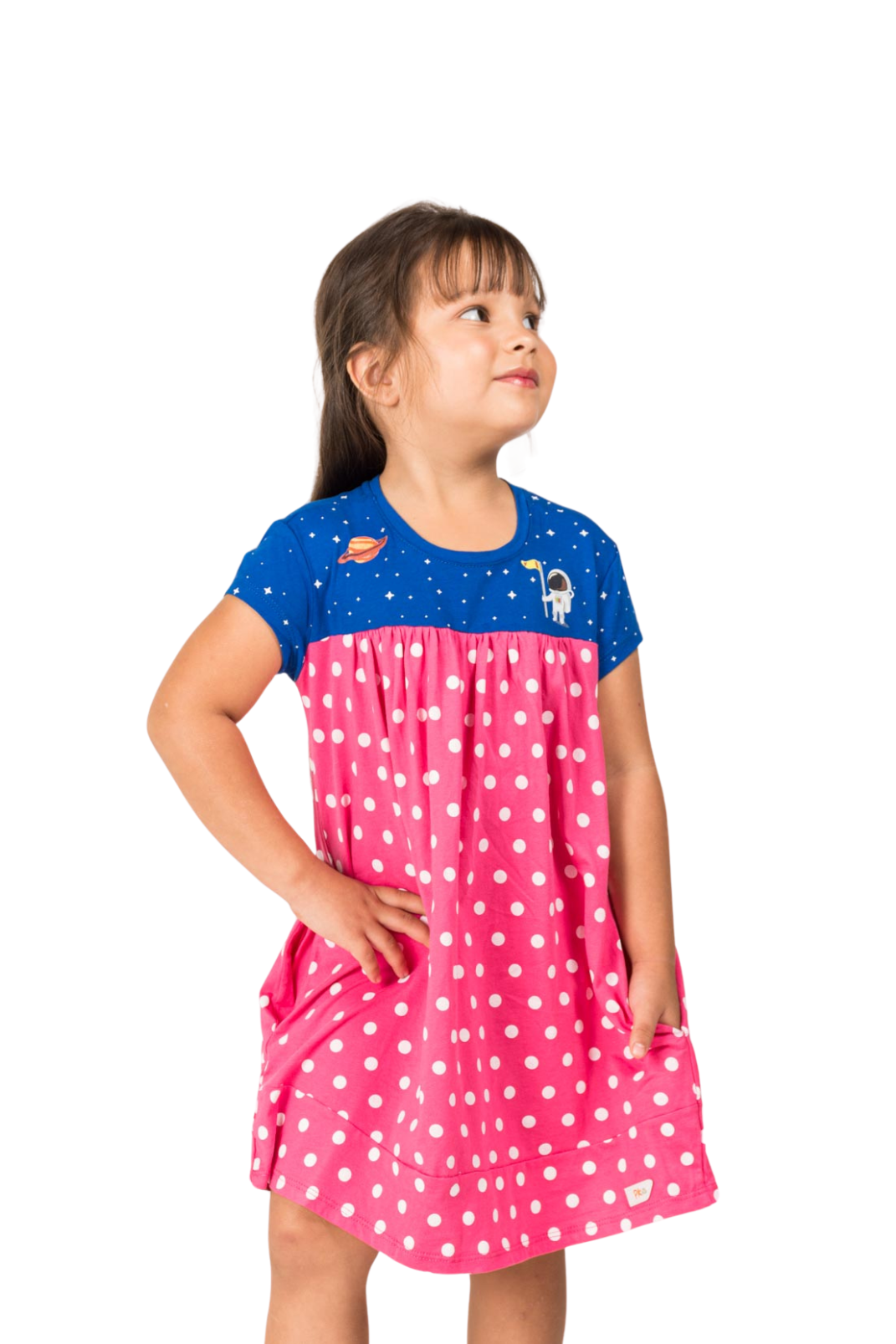 Young girl wearing a vibrant wild berry pink and navy blue empire dress featuring a starry night pattern with detailed astronaut and Saturn prints.