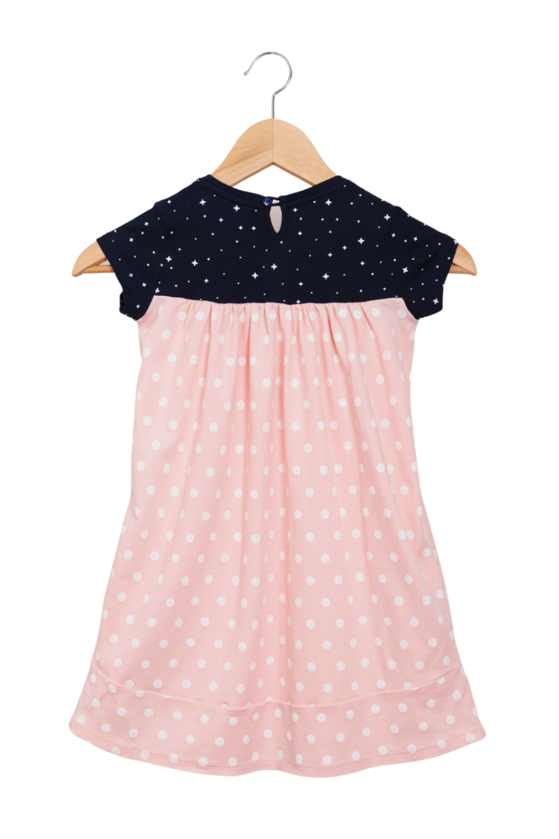 Close up of a soft pink girl's dress with a starry galaxy pattern, detailed Saturn and astronaut prints on the chest, and deep pockets in the skirt.