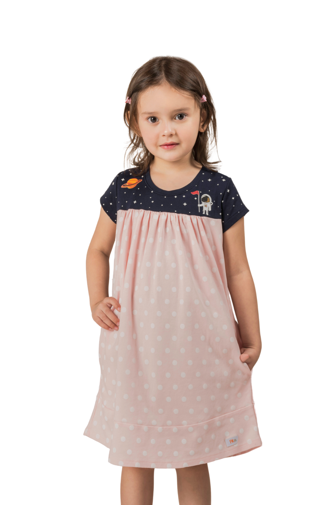Close up of a soft pink girl's dress with a starry galaxy pattern, detailed Saturn and astronaut prints on the chest, and deep pockets in the skirt.