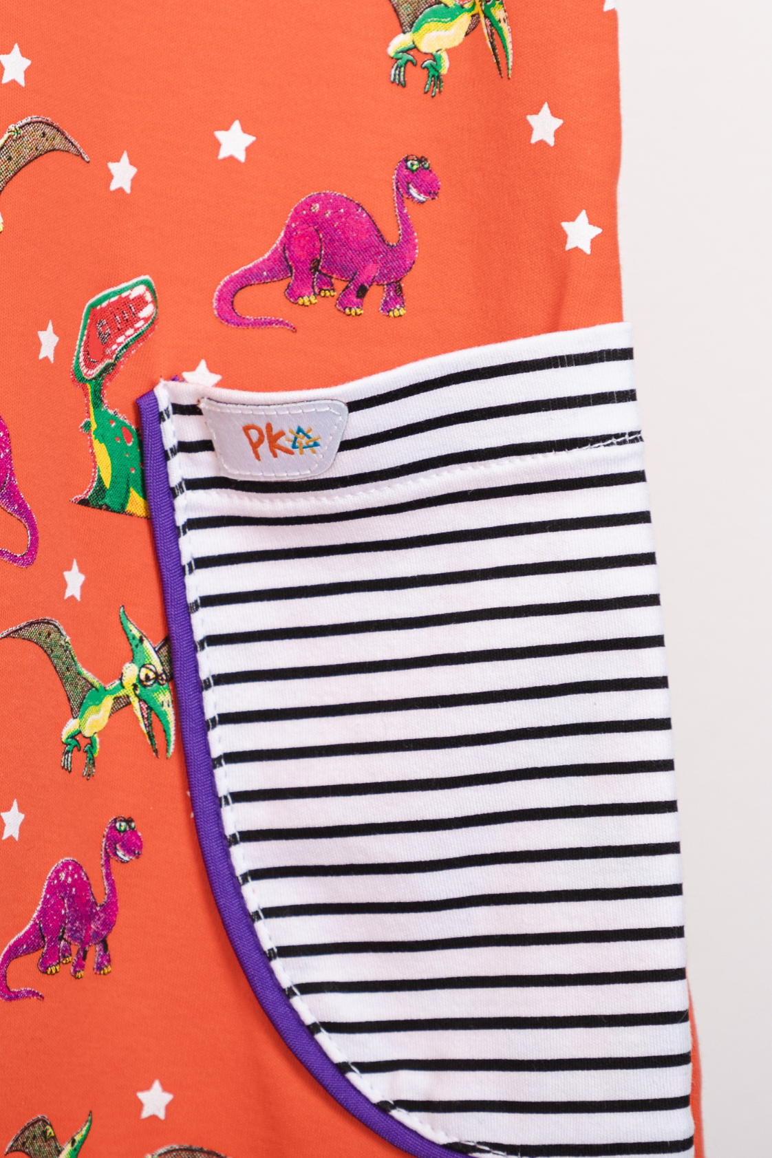 Little Girls coral pink short-sleeve dress featuring a fade-resistant T-Rex print and horizontal striped front pockets.