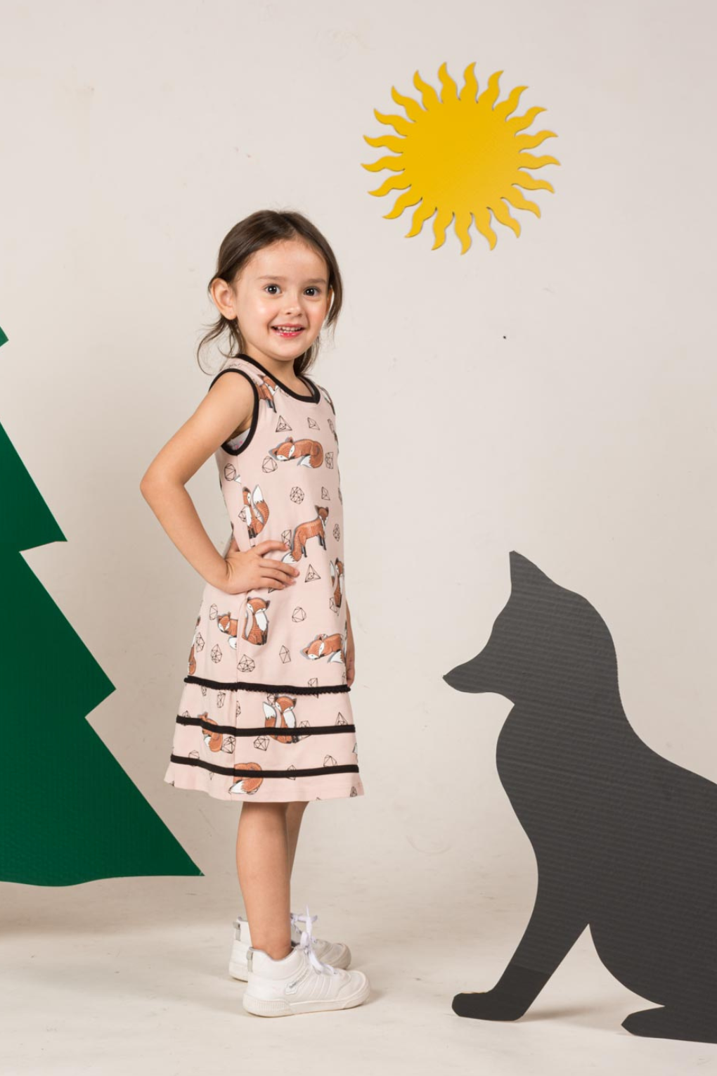 Bright pink sleeveless tent-style dress for girls adorned with a playful geometric fox and gemstone print, showing side seam pockets.
