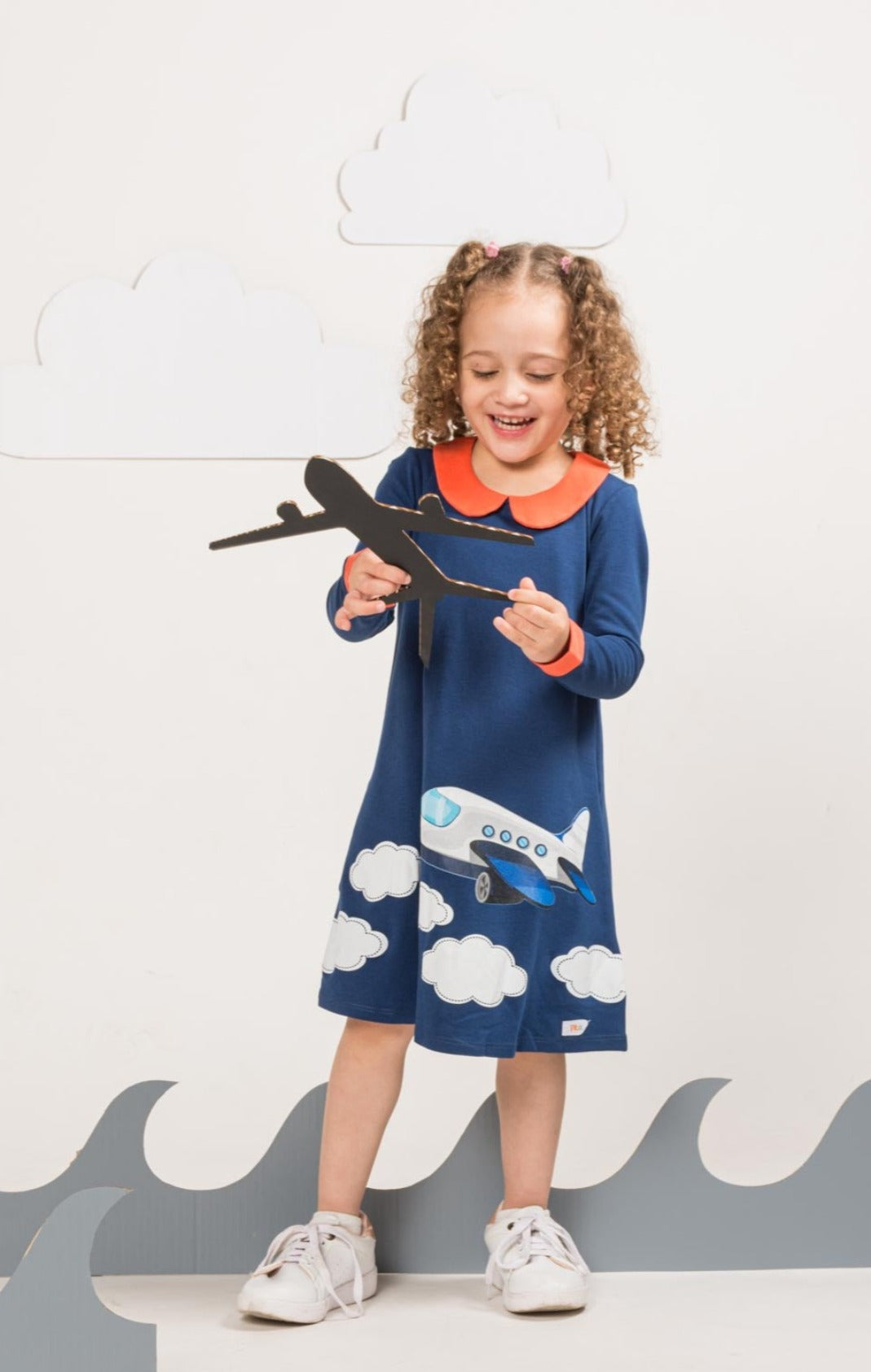 Young girl wearing vibrant children’s outfit from Prisma Kiddos. Airplane dress.