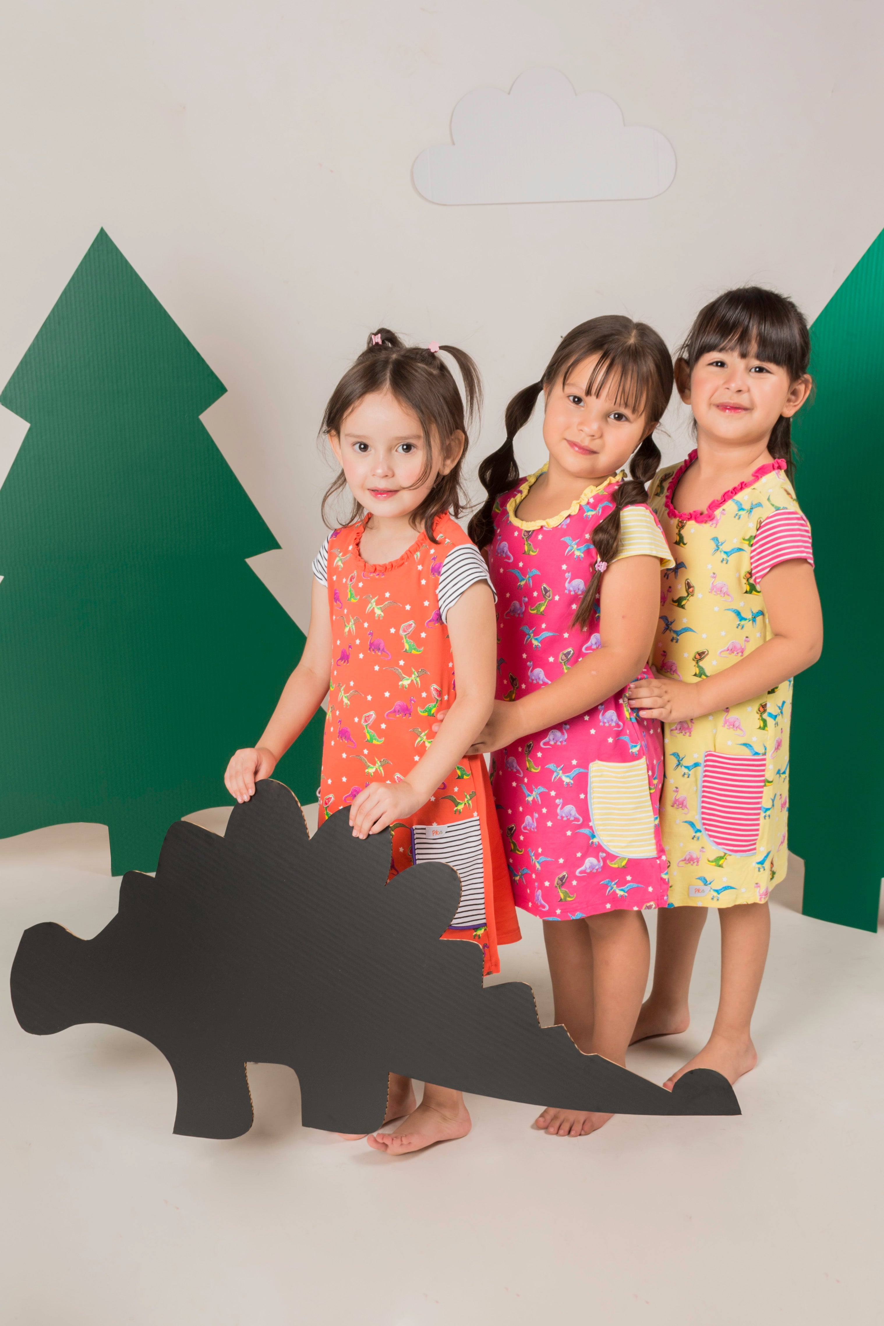 Three children wearing colorful STEM-themed clothing