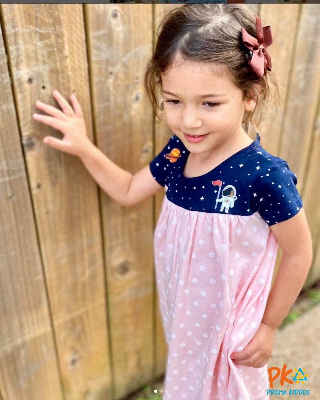 Young girl wearing a stylish STEM-inspired outfit, confidently posing outdoors.