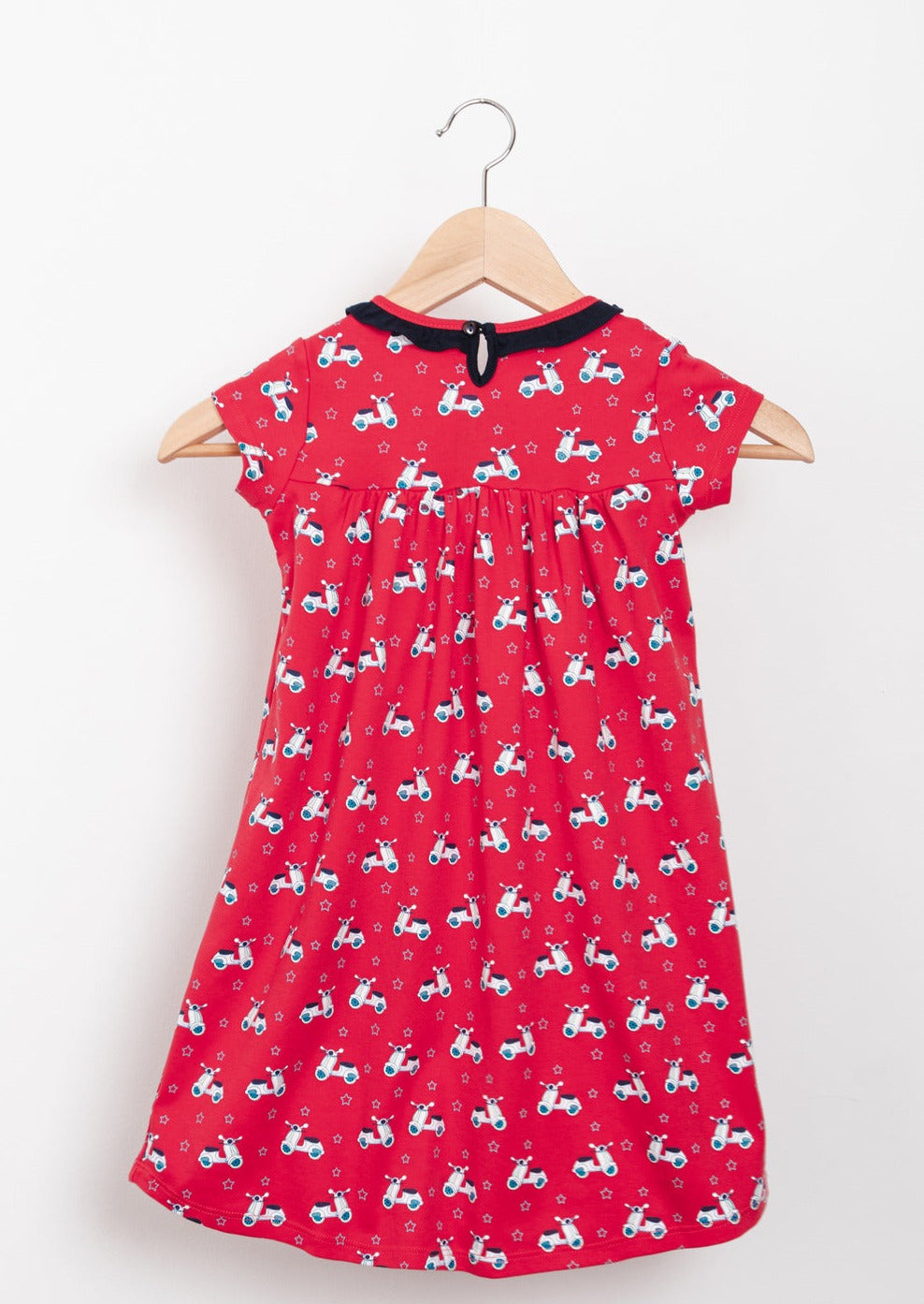 Red scooter-themed empire dresses with star-lined pockets, tailored from premium cotton.